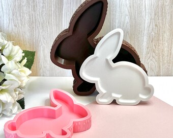 May include: Three bunny-shaped silicone molds, one brown, one white, and one pink. The molds are all in the shape of a rabbit with long ears.