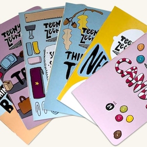 May include: A set of six colorful notebooks with the words "Teeny Zeeny" on the covers. Each notebook has a different design, including a seagull, a candy cane, a suitcase, and a leaf.