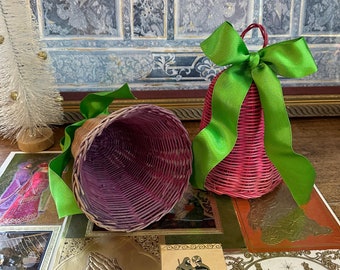 May include: Two pink wicker bells with green ribbon bows. The bells are handmade and have a rustic, vintage look.