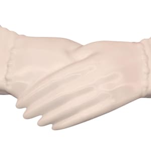 Puede incluir: Un par de manos de cerámica blanca entrelazadas, una escultura decorativa.