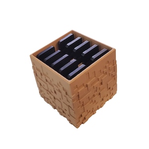 May include: A small, cube-shaped storage box with a textured, brown exterior. The box has a removable lid and is filled with black rectangular compartments.