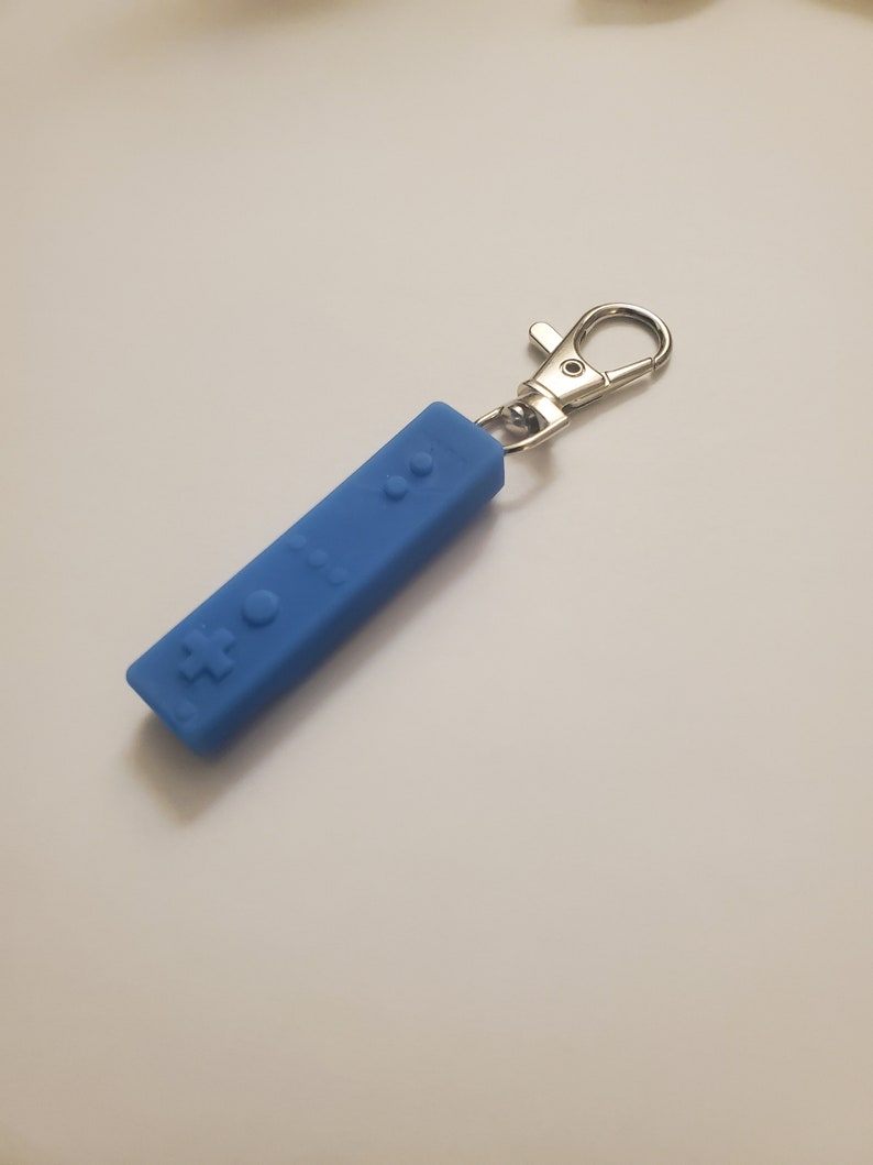 May include: A blue silicone keychain shaped like a Nintendo Wii remote.