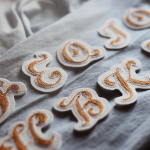 Parches de monograma con letras cosidas en cadena