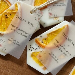 Personalized burnt orange soy wax sachet favors featuring dried orange slices, handmade soy wax air fresheners and custom vellum labels with names and dates. Elegant wedding favors, bridal shower favors, baby shower gifts, engagement party favors and wedding guest favors. Neutral boho decor with natural botanicals and premium fragrance oils. Perfect for wedding welcome bags, bridesmaid gifts, bridal events and special celebrations.
