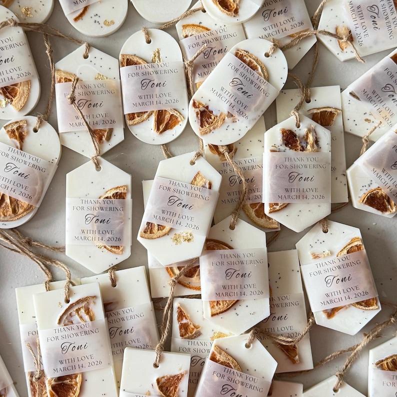 Personalized burnt orange soy wax sachet favors featuring dried orange slices, handmade soy wax air fresheners and custom vellum labels with names and dates. Elegant wedding favors, bridal shower favors, baby shower gifts, engagement party favors and wedding guest favors. Neutral boho decor with natural botanicals and premium fragrance oils. Perfect for wedding welcome bags, bridesmaid gifts, bridal events and special celebrations.