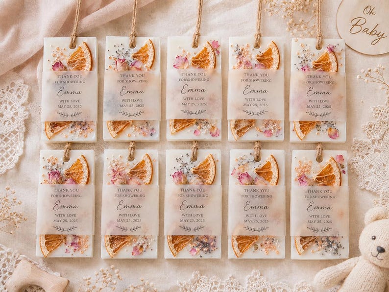 Personalized burnt orange soy wax sachet favors featuring dried orange slices, handmade soy wax air fresheners and custom vellum labels with names and dates. Elegant wedding favors, bridal shower favors, baby shower gifts, engagement party favors and wedding guest favors. Neutral boho decor with natural botanicals and premium fragrance oils. Perfect for wedding welcome bags, bridesmaid gifts, bridal events and special celebrations.