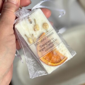 Personalized burnt orange soy wax sachet favors featuring dried orange slices, handmade soy wax air fresheners and custom vellum labels with names and dates. Elegant wedding favors, bridal shower favors, baby shower gifts, engagement party favors and wedding guest favors. Neutral boho decor with natural botanicals and premium fragrance oils. Perfect for wedding welcome bags, bridesmaid gifts, bridal events and special celebrations.