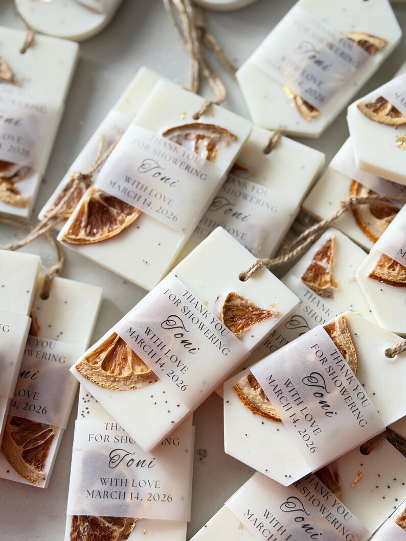 Personalized burnt orange soy wax sachet favors featuring dried orange slices, handmade soy wax air fresheners and custom vellum labels with names and dates. Elegant wedding favors, bridal shower favors, baby shower gifts, engagement party favors and wedding guest favors. Neutral boho decor with natural botanicals and premium fragrance oils. Perfect for wedding welcome bags, bridesmaid gifts, bridal events and special celebrations.