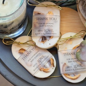 Personalized burnt orange soy wax sachet favors featuring dried orange slices, handmade soy wax air fresheners and custom vellum labels with names and dates. Elegant wedding favors, bridal shower favors, baby shower gifts, engagement party favors and wedding guest favors. Neutral boho decor with natural botanicals and premium fragrance oils. Perfect for wedding welcome bags, bridesmaid gifts, bridal events and special celebrations.