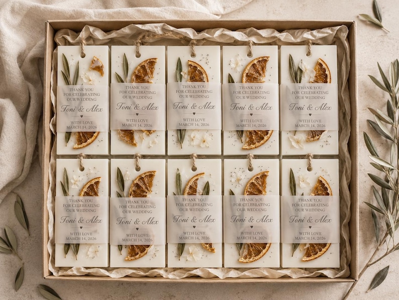 Personalized burnt orange soy wax sachet favors featuring dried orange slices, handmade soy wax air fresheners and custom vellum labels with names and dates. Elegant wedding favors, bridal shower favors, baby shower gifts, engagement party favors and wedding guest favors. Neutral boho decor with natural botanicals and premium fragrance oils. Perfect for wedding welcome bags, bridesmaid gifts, bridal events and special celebrations.