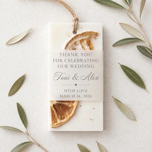 Personalized burnt orange soy wax sachet favors featuring dried orange slices, handmade soy wax air fresheners and custom vellum labels with names and dates. Elegant wedding favors, bridal shower favors, baby shower gifts, engagement party favors and wedding guest favors. Neutral boho decor with natural botanicals and premium fragrance oils. Perfect for wedding welcome bags, bridesmaid gifts, bridal events and special celebrations.