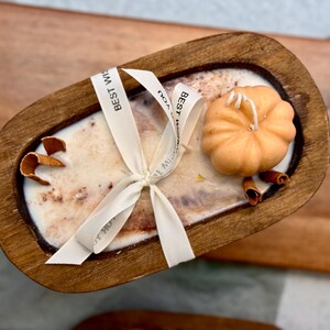 Handmade wooden dough bowl pumpkin candle with soy wax and dried botanicals, perfect as an autumn candle or pumpkin candle gift. Rustic design enhances autumn home decor and autumn decorations, while warm fragrance makes it an ideal Thanksgiving candle. Use as pumpkin decor, cozy centerpiece, or thoughtful Thanksgiving gifts. Unique handmade candles for Thanksgiving decor and seasonal charm, reusable rustic bowl.