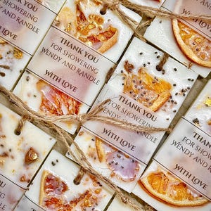 Personalized burnt orange soy wax sachet favors featuring dried orange slices, handmade soy wax air fresheners and custom vellum labels with names and dates. Elegant wedding favors, bridal shower favors, baby shower gifts, engagement party favors and wedding guest favors. Neutral boho decor with natural botanicals and premium fragrance oils. Perfect for wedding welcome bags, bridesmaid gifts, bridal events and special celebrations.