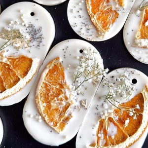 Personalized burnt orange soy wax sachet favors featuring dried orange slices, handmade soy wax air fresheners and custom vellum labels with names and dates. Elegant wedding favors, bridal shower favors, baby shower gifts, engagement party favors and wedding guest favors. Neutral boho decor with natural botanicals and premium fragrance oils. Perfect for wedding welcome bags, bridesmaid gifts, bridal events and special celebrations.