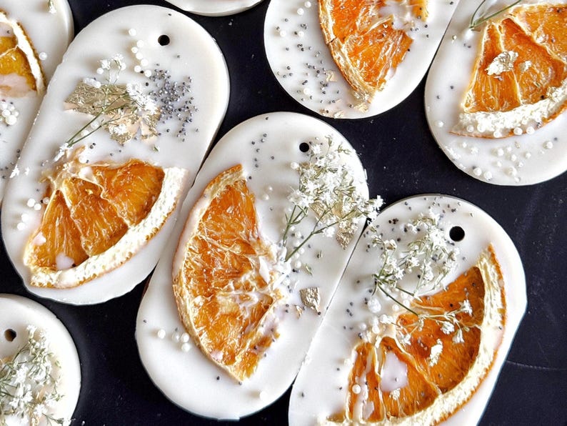Personalized burnt orange soy wax sachet favors featuring dried orange slices, handmade soy wax air fresheners and custom vellum labels with names and dates. Elegant wedding favors, bridal shower favors, baby shower gifts, engagement party favors and wedding guest favors. Neutral boho decor with natural botanicals and premium fragrance oils. Perfect for wedding welcome bags, bridesmaid gifts, bridal events and special celebrations.