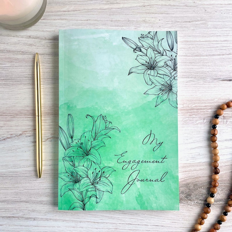 May include: A green watercolor journal with black floral illustrations and the text "My Engagement Journal".