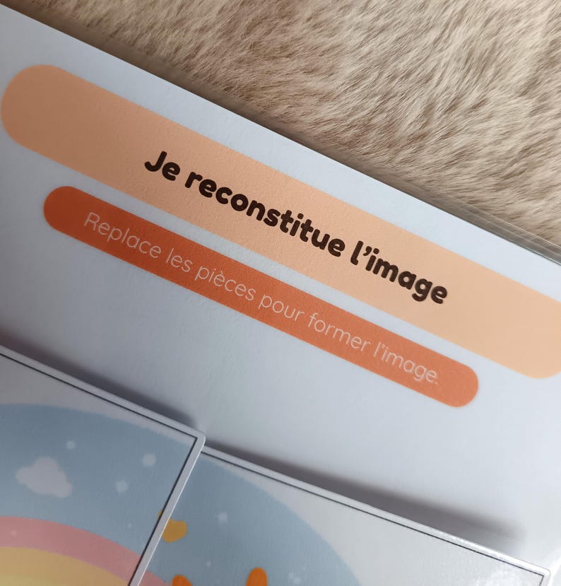 K&ouml;nnte beinhalten: Nahaufnahme einer Puzzlebox mit franz&ouml;sischem Text. Der Text lautet "Je reconstitue l'image" und "Replace les pi&egrave;ces pour former l'image". Die Box hat ein pfirsichfarbenes und orangefarbenes Design.