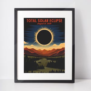 Puede incluir: Impresión artística enmarcada que representa un eclipse solar total. La obra presenta un círculo negro rodeado por una corona brillante sobre un cielo azul oscuro. El texto "TOTAL SOLAR ECLIPSE August 12, 2026" se muestra en la parte superior. El paisaje incluye montañas y árboles.