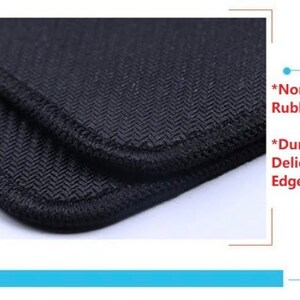 Op de afbeelding: Close-up van een zwarte muismat met een textuur en een gestikte rand. De muismat heeft een antislip rubberen basis.