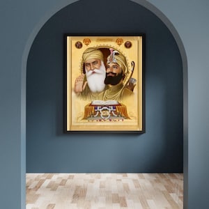 Puede incluir: Una pintura enmarcada que representa a dos gurús sij, Guru Nanak y Guru Gobind Singh, en un estilo tradicional. La pintura presenta un fondo dorado con detalles intrincados y los gurús visten turbantes y túnicas de colores.