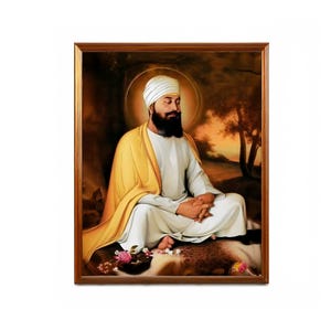 May include: A framed painting depicting a man wearing a white turban and robe, seated in a meditative pose with his hands clasped. The background features a landscape with trees and a sunset.