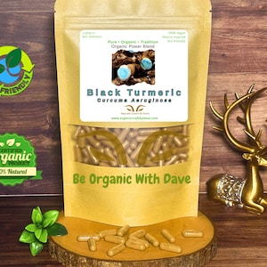 May include: A package of black turmeric capsules with a clear window, displayed on a wooden surface. The label reads "Black Turmeric Curcuma Aeruginosa." The package is labeled "Organic Power Blend" and "Be Organic With Dave."