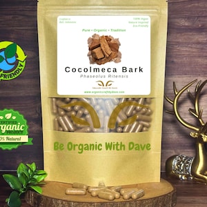 May include: A clear plastic bag filled with brown capsules, labeled "Cocolmeca Bark". The bag is on a wooden surface, with a gold deer statue to the right. The text "Be Organic With Dave" is visible.