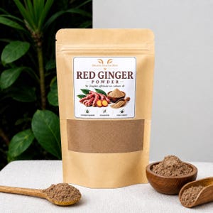 Puede incluir: Una bolsa vertical de color canela con polvo de jengibre rojo y una etiqueta con el texto Organic Craft by Dave, Red Ginger Powder y Zingiber officinale var. rubrum. La bolsa se acompaña de una cuchara de madera y un cuenco de madera con polvo.