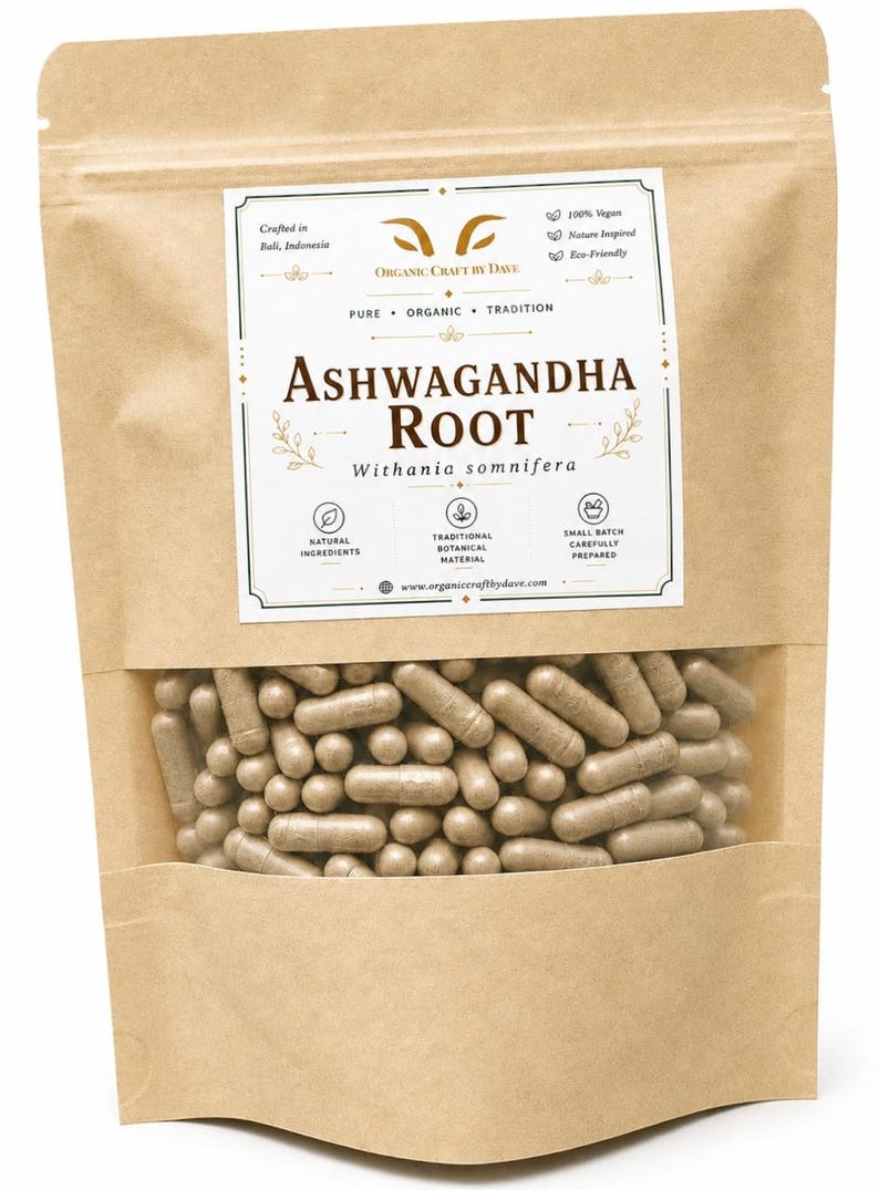 May include: A brown paper bag with a clear window, filled with numerous light brown capsules. The bag features a label with the text "ASHWAGANDHA ROOT" and other details about the product, including "Organic Craft by Dave."