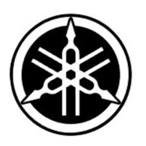 Puede incluir: Logotipo de Yamaha en blanco y negro. El logotipo presenta un emblema estilizado dentro de un círculo negro, con tres formas de flecha que irradian hacia afuera. El emblema tiene un diseño geométrico central con una serie de líneas y formas.