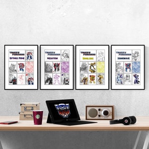 Pode incluir: Quatro impressões emolduradas de personagens Transformers, cada uma com um esquema de cores diferente. Os personagens são Optimus Prime, Megatron, Bumblebee e Soundwave. As impressões estão penduradas em uma parede branca acima de uma mesa com um laptop, um rádio e fones de ouvido.