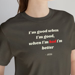 May include: A dark gray t-shirt with a white quote that reads "I'm good when I'm good, when I'm bad I'm better - Jessi"