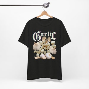 Może przedstawiać: Czarny T-shirt z grafiką ząbków czosnku i napisem "Garlic" w kolorowej, glitchowej czcionce.