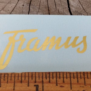 May include: Gold "Framus" logo sticker on a light blue background.