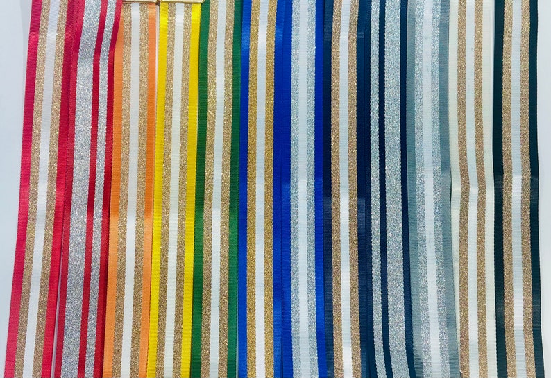 May include: Assortment of striped ribbon with gold glitter accents. The ribbons are in various colors including red, orange, yellow, green, blue, and gray.