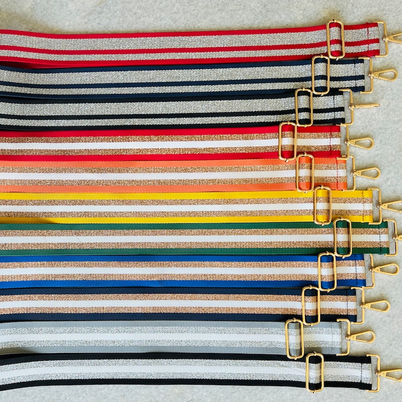 May include: A set of ten striped fabric straps with gold metal hardware. The straps are in various colors, including red, black, white, orange, yellow, green, and blue.