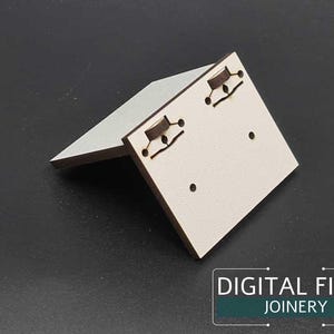 May include: White wooden earring display stand with two holes for earrings. The stand is angled and has a textured surface. The stand is on a black background.