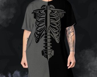 May include: A gray and black T-shirt dress featuring a skeletal rib cage design. The dress is split vertically, with one side in gray and the other in black. The skeleton graphic is in a darker gray.