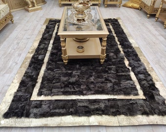 Puede incluir: Una alfombra rectangular que presenta un panel central de textura peluda en color marrón oscuro, bordeado por un marco ancho de tono dorado metálico. La alfombra tiene una apariencia en capas con una superficie de pelo largo y un borde dorado liso.