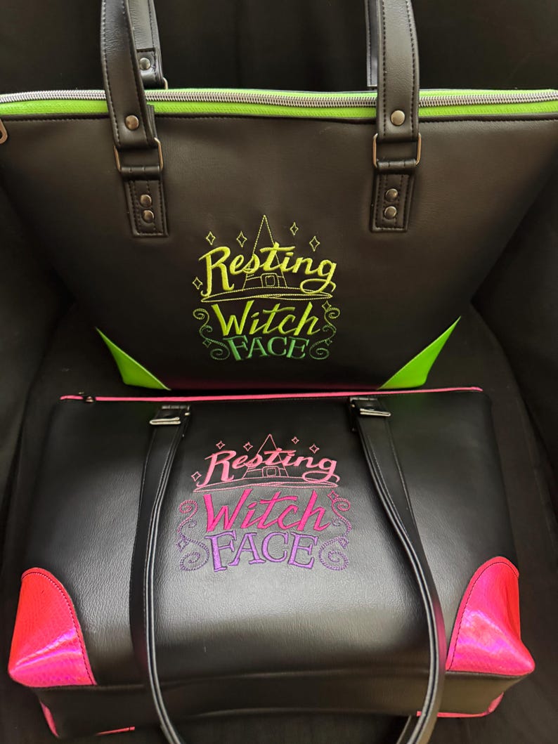 May include: Two black tote bags with the text "Resting Witch Face" embroidered on the front. The top bag has green trim and accents, while the bottom bag features pink trim and accents. Both bags have handles.