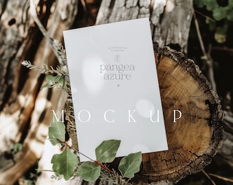Puede incluir: Una maqueta de tarjeta blanca con el texto "pange azure" y "MOCKUP" sobre un tocón de árbol con follaje verde.