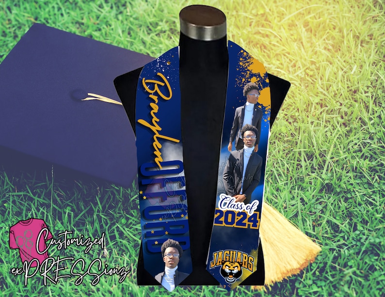 May include: A blue and gold graduation stole with a personalised name, "Braylen", and the text "Class of 2024" and "Jaguars". The stole features a photo of a graduate in a cap and gown.
