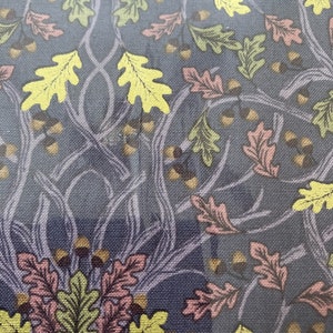 Peut inclure: Un tissu bleu avec un motif répétitif de feuilles de chêne jaunes, vertes et roses et de glands.