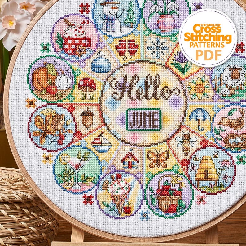 K&ouml;nnte beinhalten: Ein Kreuzstichmuster in einem Holzreifen mit einem farbenfrohen Design mit dem Text "Hello June". Das Design enth&auml;lt verschiedene saisonale Motive wie einen Schneemann, Blumen und Eiswaffeln. Der Text "The World of Cross Stitching Patterns PDF" ist ebenfalls sichtbar.