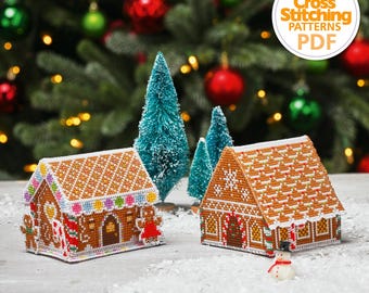 Op de afbeelding: Twee kruissteekpatronen van gingerbread houses, een met een snoepstok en de andere met een sneeuwpop. De patronen zijn op een witte achtergrond met een sneeuweffect. De tekst "The World of Cross Stitching Patterns PDF" staat in een gele cirkel.