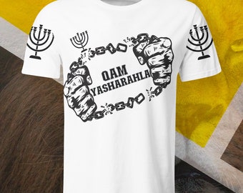 May include: White t-shirt with a black graphic of two hands breaking free from chains. The text "QAM YASHARAHLA" is inside the chain circle. There are three menorahs on the shirt.
