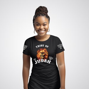 Puede incluir: Camiseta negra con un gráfico de león blanco y el texto "Tribe of Judah" con una menorá a cada lado del león.