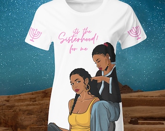 May include: White t-shirt with a pink graphic that says "it's the Sisterhood! for me". The graphic features two Black women with long hair. One woman is styling the other's hair. The shirt has a pink menorah design on each sleeve.
