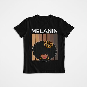 May include: Black t-shirt with the word "MELANIN" in white letters and a graphic of a woman with an afro wearing a crown and earrings. The graphic is surrounded by a series of brown stripes.