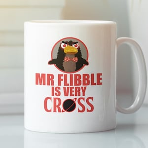May include: White ceramic mug with a red and black cartoon character with the text "Mr Flibble is very cross" printed on it.